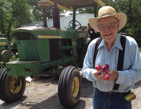 Joe standing in front of a Tractor Holding Radishes Joe standing in front of a Tractor Holding Radishes