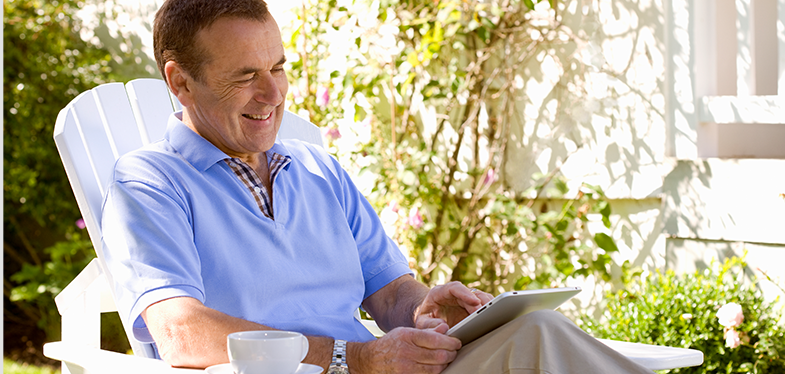 Man sitting outside on a lawn chair using an ipad